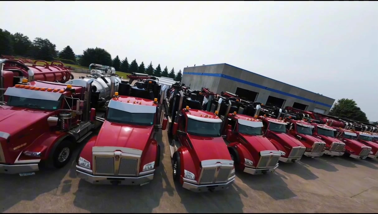 Red hydrovac trucks lined up outside the shop