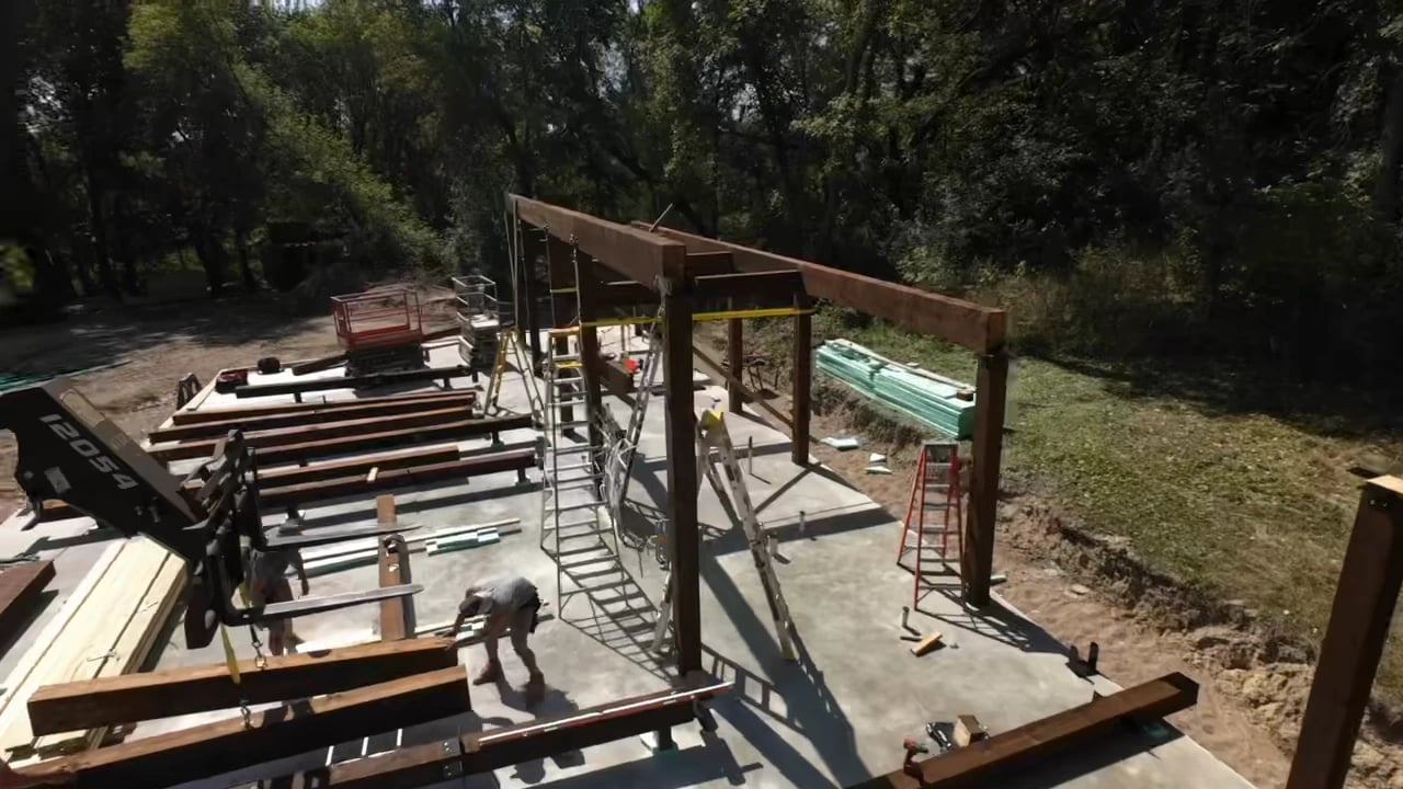 Timber columns and beams standing on the slab as the structure is assembled