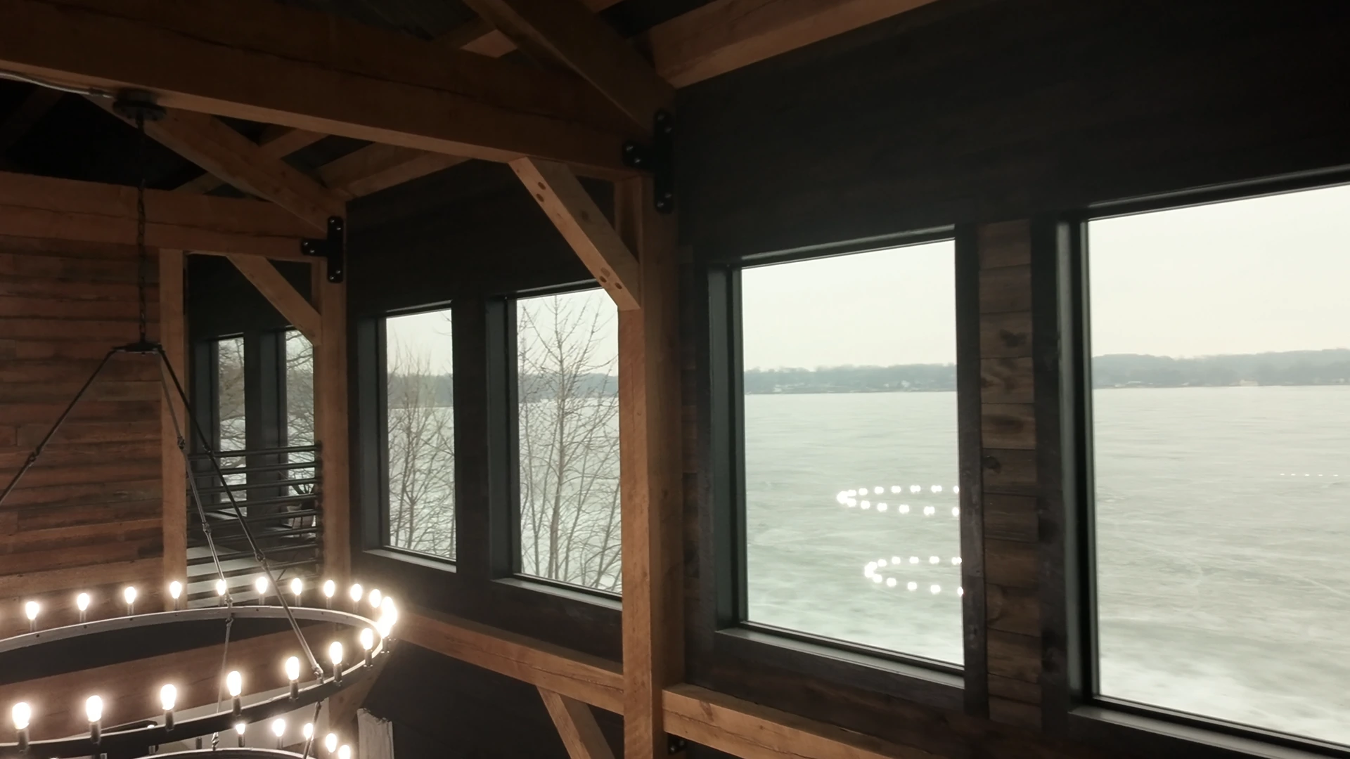 Tall windows framing Spring Lake beyond the timber living space